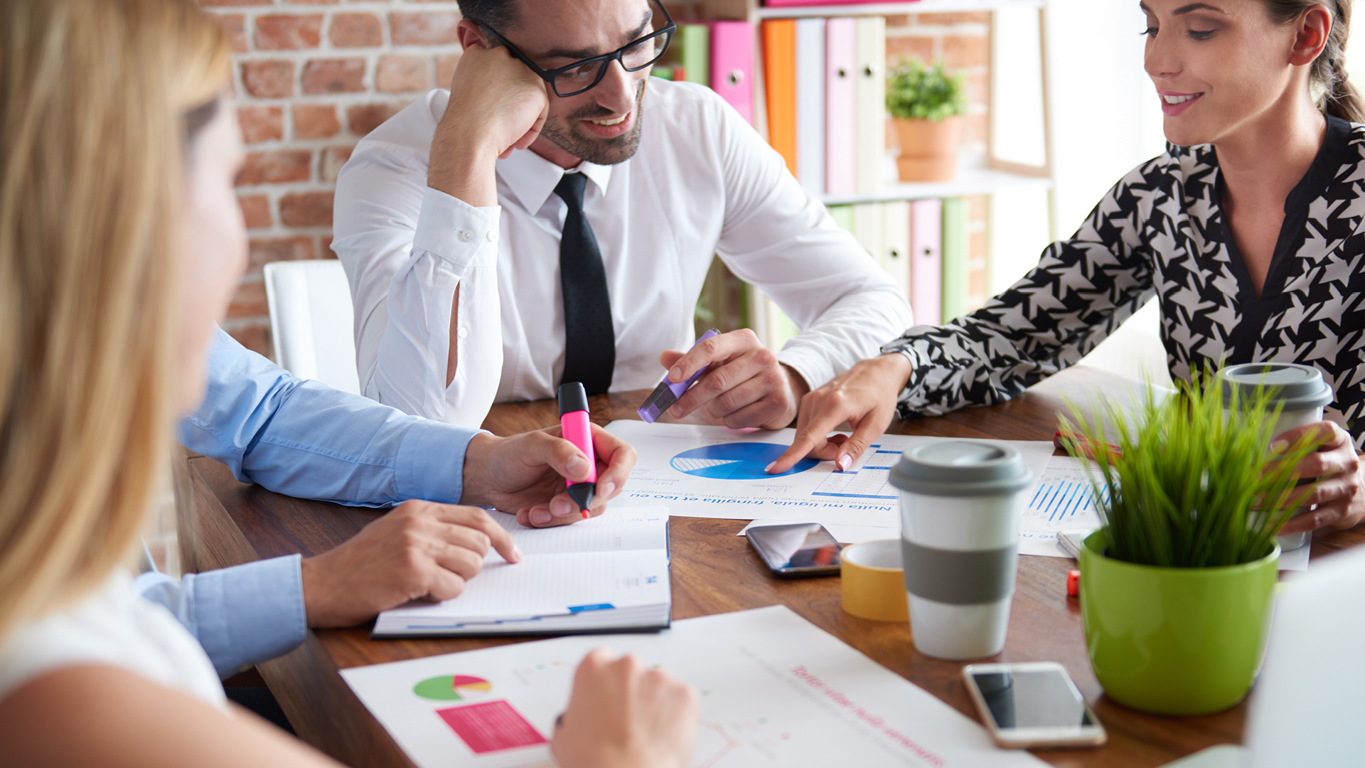 Team of business professionals review documents on their office table.