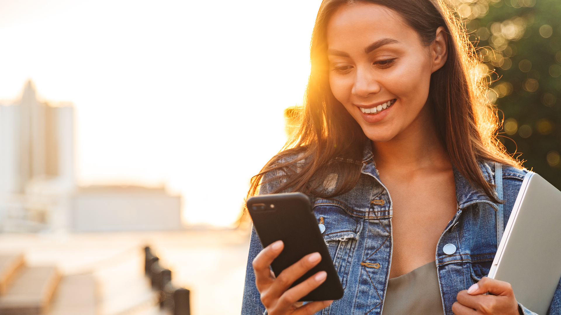 Smiling woman using mobile banking on her cell phone.