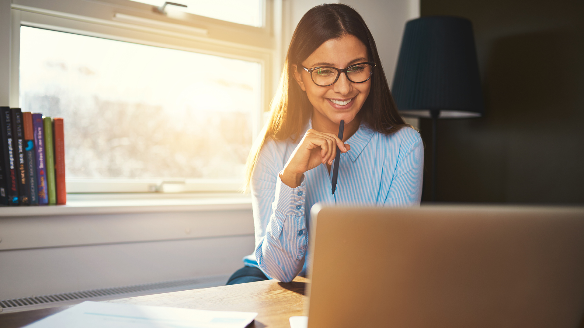 Woman reviewing finances on laptop at home.