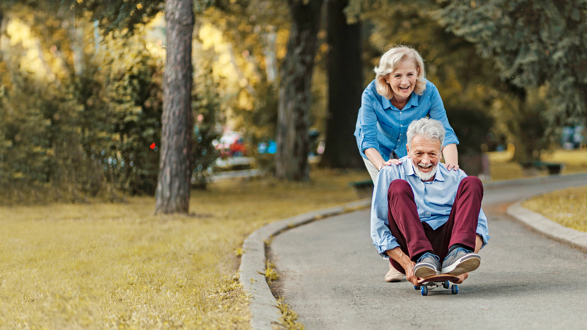 Senior couple having fun with a skateboard.