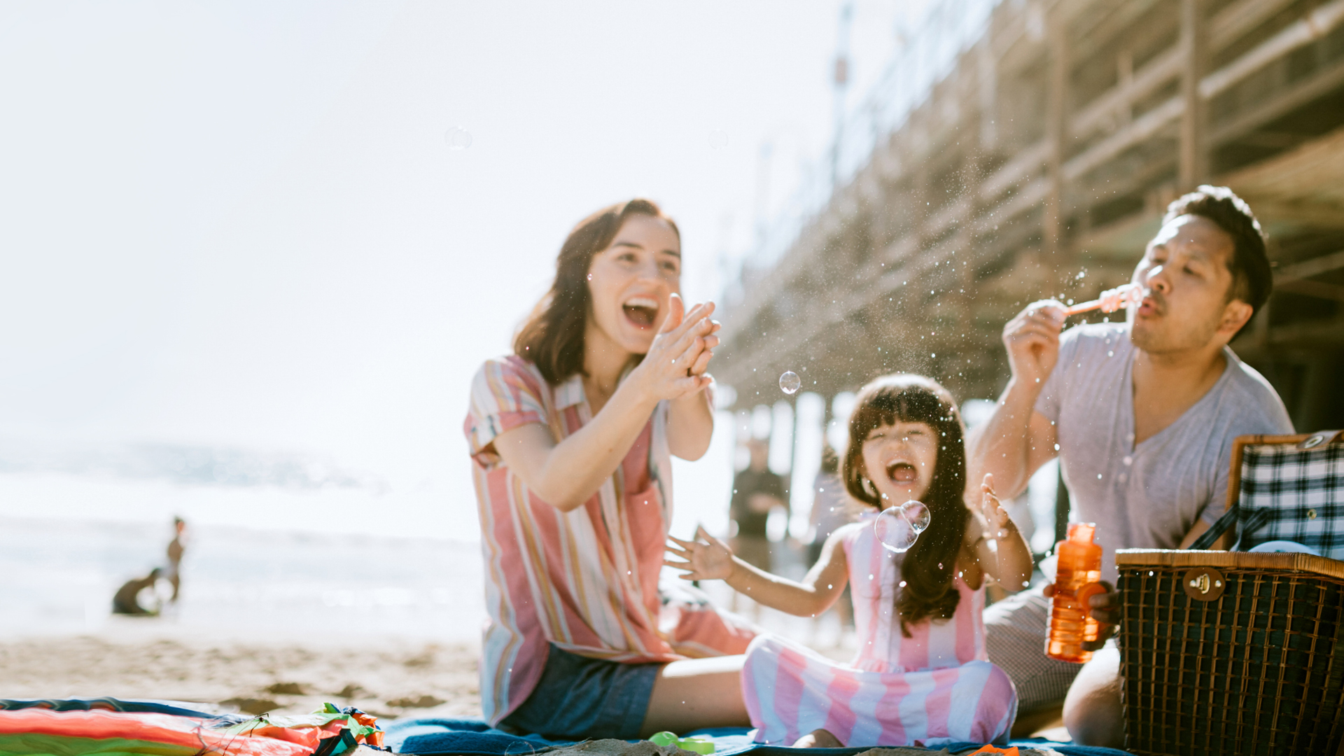 Family at Pismo Beach blowing bubbles on the sand.