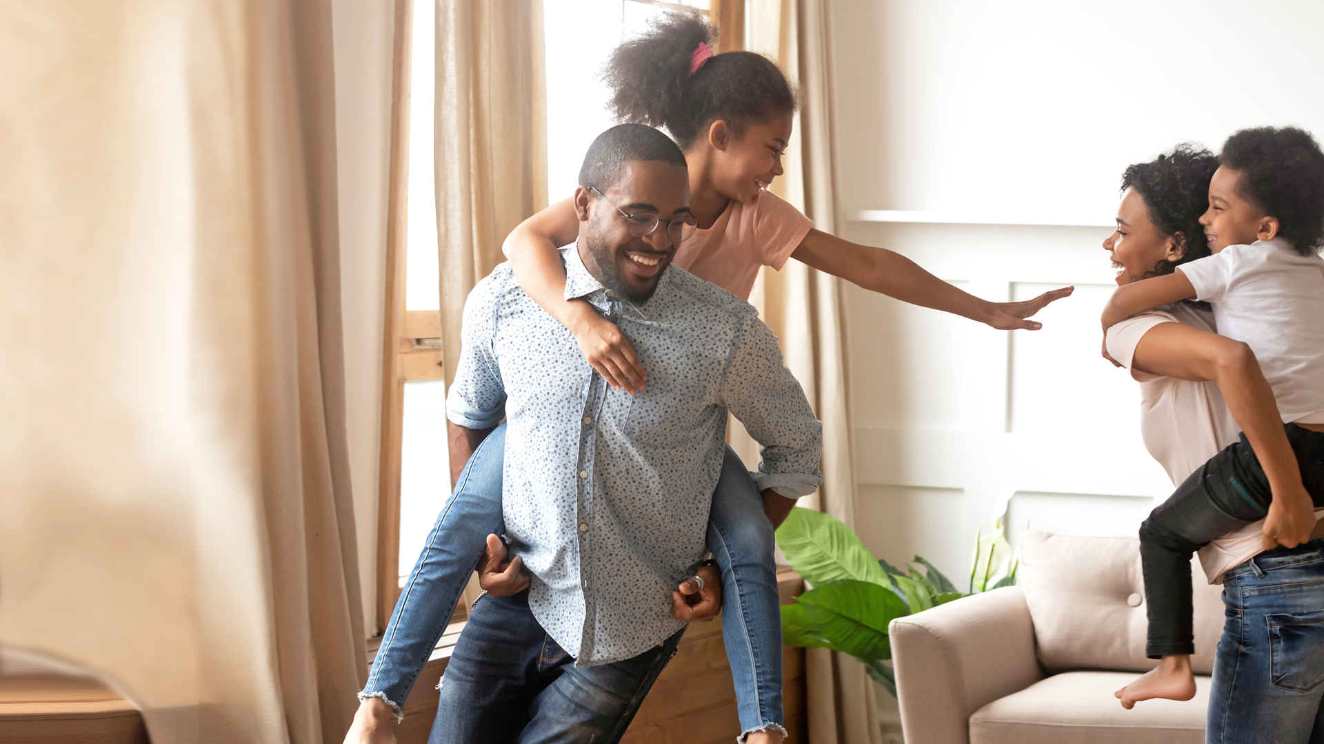 Parents giving kids piggyback rides chase each other around the house.