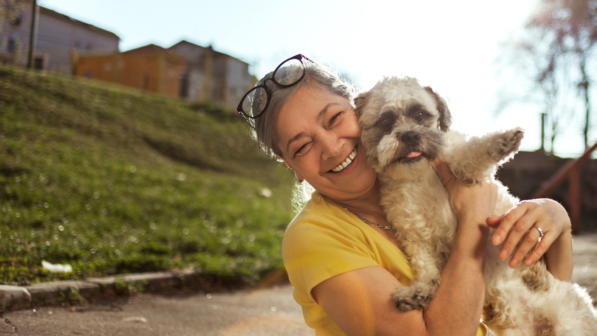 Senior woman in park with her little dog.