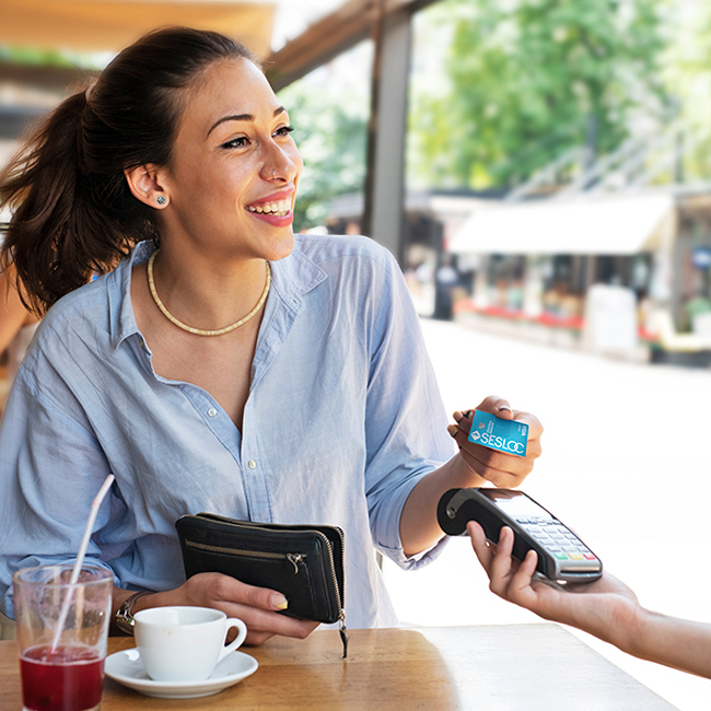 Woman paying for a meal with her SESLOC Visa debit card.