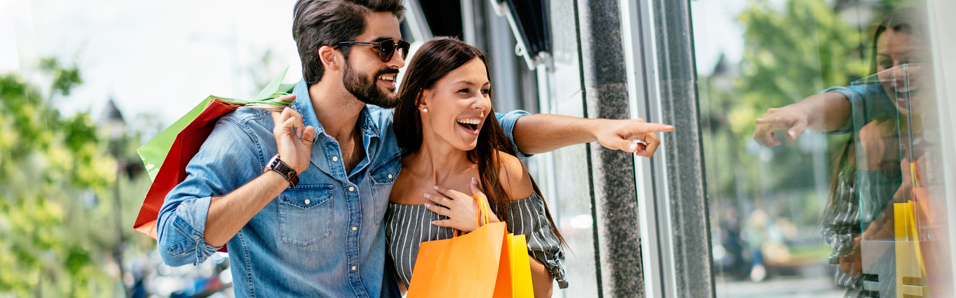 A couple is window shopping with their SESLOC Visa Signature Rewards credit card.