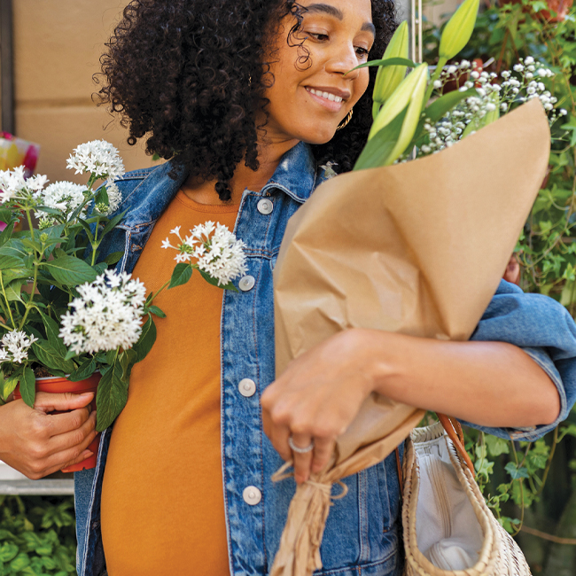 A woman buys flowers with her SESLOC Visa Rewards credit card.