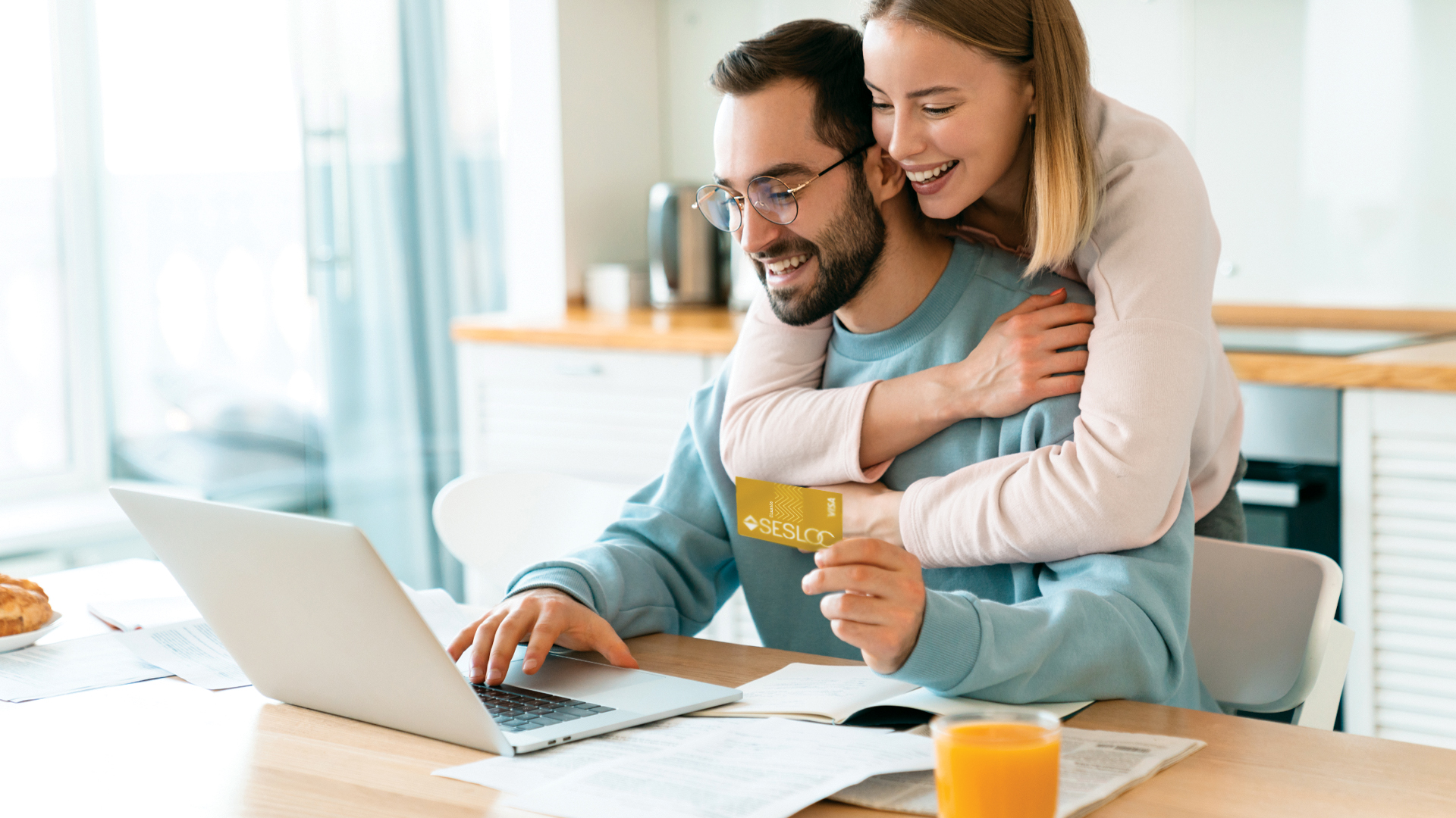 A couple at home on their laptop uses SESLOC's Card Services while planning their trip.