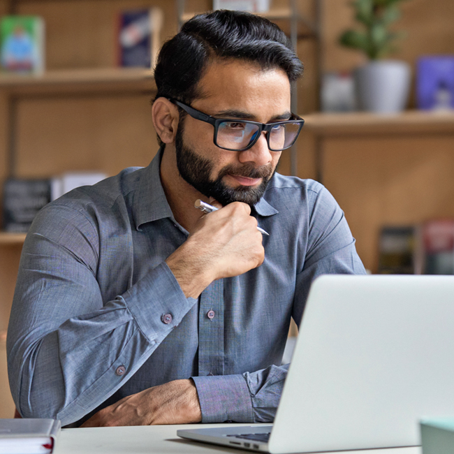 man on laptop uses SESLOC's online banking