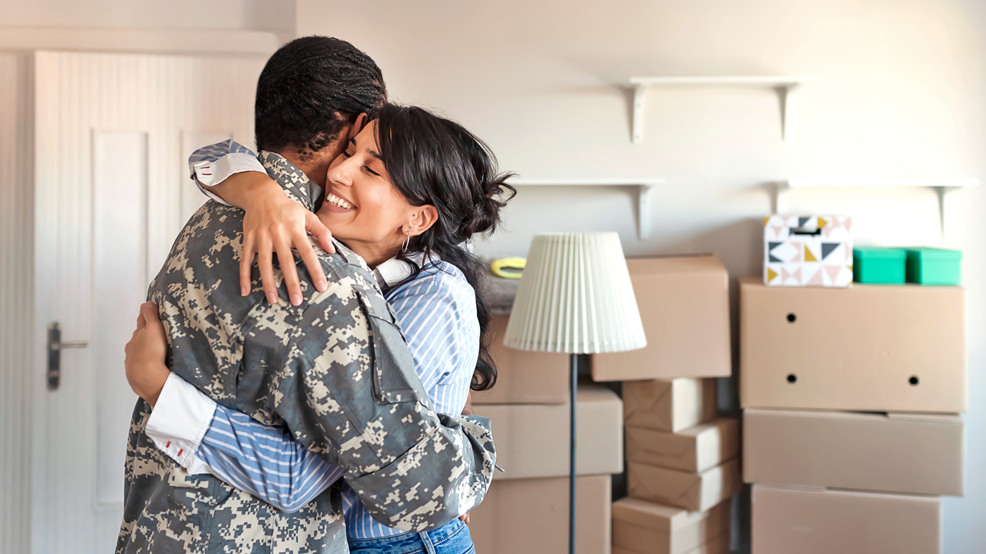 A veteran embraces his wife after moving into their new home.